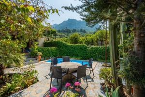 a patio with a table and chairs in a garden at Cas Patró Lau Bis in Fornalutx