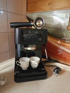 Una cafetera con dos tazas en un mostrador en Dom w Jabłonkach Wakacje, Kaszuby, Chmielno, Sznurki Gwiezdna 24, en Chmielno