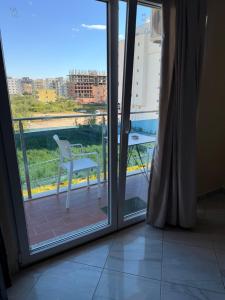 a room with a sliding glass door with a chair on a balcony at Royal holiday apartamentes in Lezhë