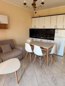 a kitchen and living room with a table and chairs at Royal holiday apartamentes in Lezhë