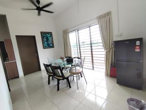 a dining room with a table and a refrigerator at The Road Stay in Kluang