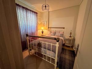 a small bedroom with a bed and a window at Alonaki House in Amfikleia