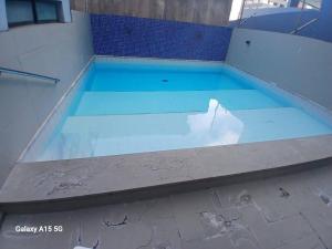 a swimming pool with blue water in the middle at Praia de Ponta Verde com lavadora, wi-fi, garagem - quarto andar in Maceió