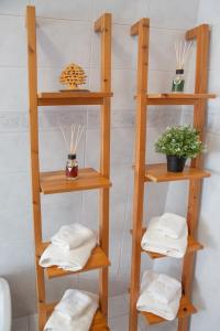 a wooden shelf with towels and a potted plant at Tra il Vesuvio e il Mare Apartment in Torre del Greco