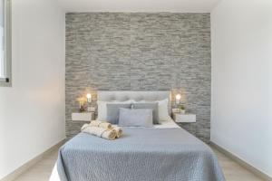 Un dormitorio con una cama grande con una pared de ladrillo. en Villa el Olivar 2, en Barbate 17 fotos más