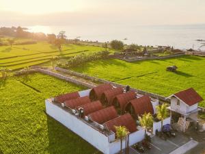 an aerial view of a house with a field and the ocean at Loka Sea View Glamping in Pengastulan