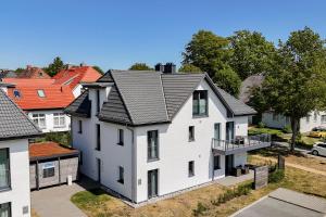ヴストロにあるSeeluft direkt an der Ostseeの黒い屋根の白い家の航空写真