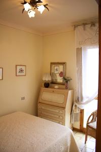a bedroom with a bed and a mirror and a dresser at Casetta in Versilia in Viareggio