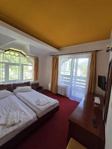 a hotel room with two beds and a window at Casa Maria Azuga by Genco in Azuga