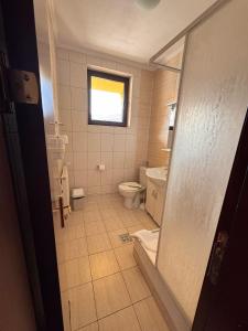 a bathroom with a toilet and a window at Casa Maria Azuga by Genco in Azuga