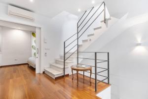 a white staircase with a round table in a living room at LovelyLoft San Anton in Alicante