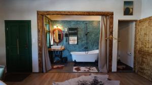 a bathroom with a tub and a sink and a mirror at Gyimesi Skanzen in Valea Boroş +143 photos