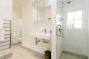 Un baño blanco con lavabo y ducha. en Beauty at the Lake, en Taupo 22 fotos más