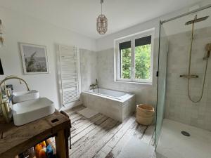 Un baño con bañera, lavabo y ducha. en Charming house for ten people, en Olivet 3 fotos más