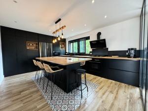 Una cocina con una gran isla con taburetes de bar. en Charming house for ten people, en Olivet
