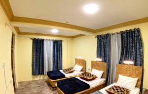a hotel room with two beds and a window at Heavens Orchard in Manāli +16 photos