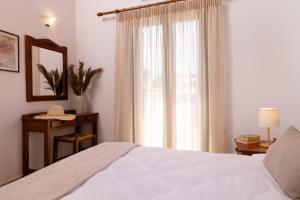 a bedroom with a white bed and a window at Villas Almyrida in Almyrida +37 photos