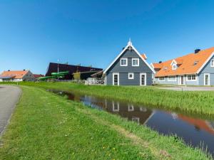 een huis aan de oever van een rivier met huizen bij Holiday Home by Beach in Ooghduyne in Julianadorp