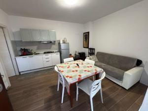 a kitchen and a living room with a table and a couch at Appartamento Morelli Beach - Via Fratti in Follonica