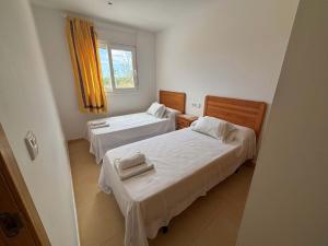 a room with two beds and a window at Condado de Alhama Jardin 4 SV86 in Alhama de Murcia