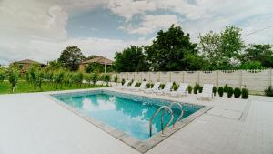 a swimming pool with white chairs and a fence at Villa Ikalto in Telavi +72 photos