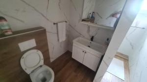 a white bathroom with a toilet and a sink at Batea 2 in Seline