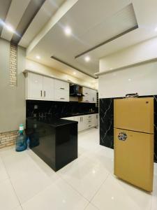 a kitchen with white cabinets and a yellow refrigerator at Luxurious Villa In Bahria Town Karachi By Luxus Residencia in Karachi +5 photos