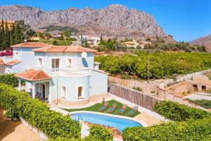 a villa with a swimming pool and mountains in the background at Villa Dalia by Villa Plus in Beniarbeig