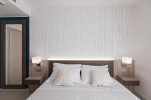 ein Schlafzimmer mit einem Bett mit weißen Laken und Kissen in der Unterkunft Hotel Palmensis in Marina Palmense + 36 Fotos