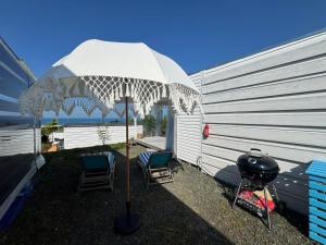 洛泽内茨Camping Gardenia - Bungalow SeaBed的两把椅子和一个烤架旁边的一把伞