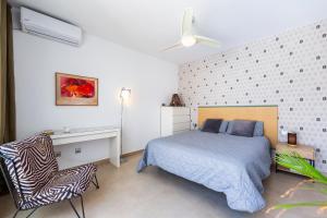 a bedroom with a bed and a desk and a chair at Casa Azahar playa Cabo De Gata 2 in Las Hortichuelas Bajas