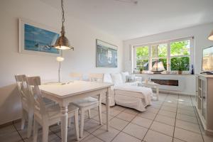 una cucina e un soggiorno con tavolo e sedie di Leuchtturm a Stakendorfer Strand