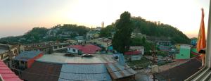a group of buildings on a hill with a town at Landour Apartment Beauty and Charm Kothri- Summer n Snow in Mussoorie