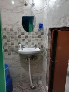 a bathroom with a sink and a mirror at Landour Apartment Beauty and Charm Kothri- Summer n Snow in Mussoorie