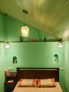 a bedroom with a bed and a green wall at Landour Apartment Beauty and Charm Kothri- Summer n Snow in Mussoorie