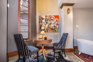 a room with two chairs and a table and a painting at Ataraxia Place in Krugersdorp