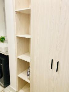 un armario con estanterías de madera en la cocina en 1br CBD Pool Gym AirCon, washer, Wi-Fi, en Mombasa
