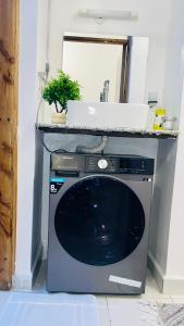 un microondas sobre un lavavajillas en 1br CBD Pool Gym AirCon, washer, Wi-Fi, en Mombasa