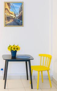 una mesa y una silla y un jarrón de flores amarillas en 1br CBD Pool Gym AirCon, washer, Wi-Fi, en Mombasa 12 fotos más