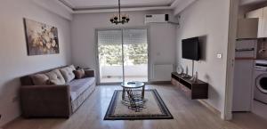 a living room with a couch and a table at ConfortTek apartment in Boumhel El Bassatine
