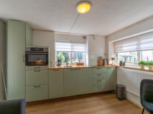 a kitchen with white cabinets and a microwave at Holiday Home in Callantsoog near Beach in Callantsoog