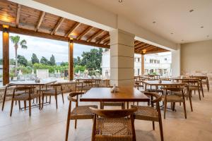 a restaurant with tables and chairs and a large window at Aegean Houses in Kos Town