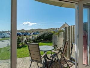 Un patio con una mesa y sillas en un porche. en Beachside Escape w Terrace, en Julianadorp