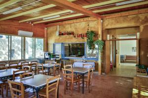 a restaurant with tables and chairs in a room at Neot Semadar Eco Lodge in Naẖal Ya‘alon