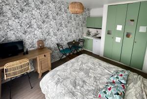 a bedroom with a bed and a desk with a tv at Le Ptit Germain in Saint-Germain-la-Blanche-Herbe