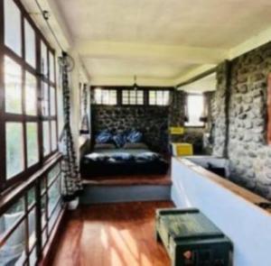 a room with a bed and a stone wall at Galunggung Basecamp Villa in Sukaratu