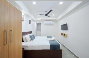a bedroom with a bed and a ceiling fan at Reach Inn in Cochin