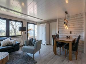 a living room with a table and a couch at Bungalow at Garnekuul park with garden in Callantsoog