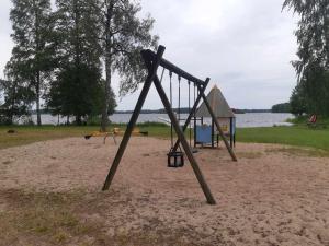 un'altalena nella sabbia vicino all'acqua di Glamping in Småland a Eksjö