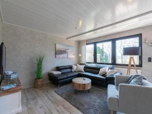 a living room with a couch and a table at Bungalow at Garnekuul park with garden in Callantsoog +16 photos